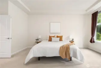 Main level primary suite is large and bright and hosts a spacious closet and en-suite.