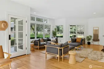 A bright, beautifully remodeled entry opens to hardwood floors, crisp millwork, and a light-filled living space framed by oversized windows. The glass-paneled door and serene views to the fenced grounds create an effortless indoor-outdoor connection, perfect for relaxing after a day in the paddocks.