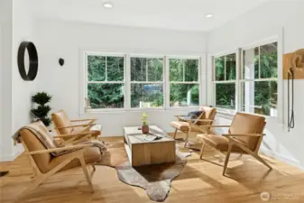 Just off the entry, this sunlit sitting room features fresh finishes and walls of windows overlooking evergreens. It’s an ideal space for morning coffee or a quiet reset after barn time, with a calm, nature-forward backdrop year-round.