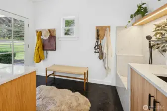 A stylish mudroom is designed for country living with durable finishes, smart storage, and a spacious dog-wash station with handheld sprayer. It’s the perfect transition space for boots, gear, and muddy paws after time in the paddocks or out on the trails.