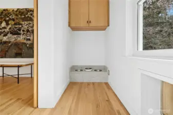 This thoughtful dog nook features a built-in feeding station and dedicated storage, seamlessly integrated into the home’s clean, modern remodel. The space can be closed off for convenience and includes a doggie door to the outside, perfect for easy in-and-out access while keeping the main living areas tidy.