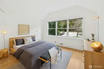The primary bedroom is bright and airy with vaulted ceilings, designer lighting, and a wall of windows that fills the space with natural light. Enjoy tranquil views over the property from your private retreat, thoughtfully finished as part of the home’s complete renovation.
