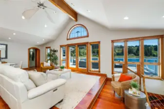Spacious living room featuring vaulted ceilings and maritime ceiling fan.