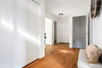 From the front door looking towards stairs, upstairs bedroom and kitchen on left, bathroom on right.