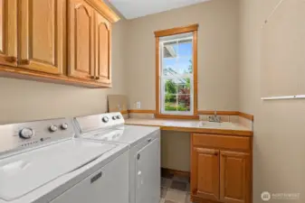 Laundry room is on the main floor with lots of cabinets and sink.