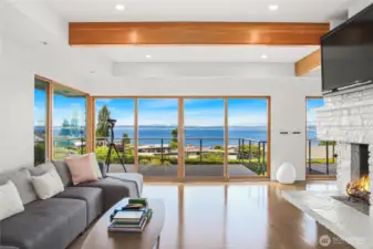 The open floor plan living area with gleaming hardwood floors and a gas burning fireplace.