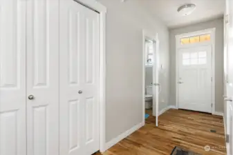 Entry way with beautiful hardwood flooring. Doorway leads to 1/2 bath.