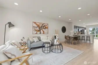 Bright and open living room with oversized windows, luxury vinyl plank flooring, and mini-split heating and A/C.