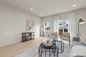 Bright and open living room with oversized windows, luxury vinyl plank flooring, and mini-split heating and A/C.