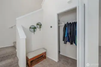 Front Entry Coat Closet, that has extra storage, and the stairs lead to the 1/2 bath and then to the laundry room and bedrooms