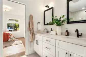 A double vanity with extra storage is capped by honed quartz counters.
