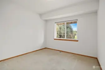 The second bedroom is just across the hall from the primary bedroom, and looks out to what was and will soon be the golf course.