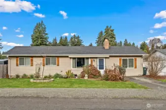 Large graveled parking area out front, and paved driveway.