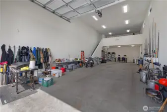 Huge attached finished shop 24x60 shop, with 20' ceilings and huge custom 14' tall by 20' wide aluminum door. Mezzanine is 424 SF. You can easily fit your boat or RV in here. Has a Twin Hybrid Hot water tanks for hot water that will not run out. Outside faucets have hot water and high pressure from a 1' main water line.