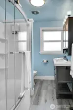 Renovated full bathroom features vinyl plank flooring