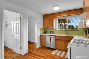 Kitchen opens to den/office, mud room, and a utility room with a half bathroom
