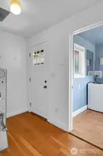 Back door and mud room flow into a utility room with a half bathroom