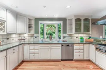 Kitchen with custom cabinets, granite counters, tiled backsplash and oak hardwood floors