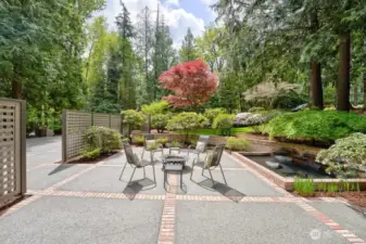 Private front concrete patio with brick inlays and circulating lighted water feature