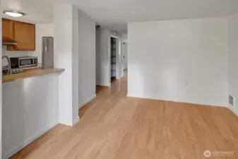 Hallway leads to utility closet  with great space for storage on left and bathroom on right with bedroom straight ahead.
