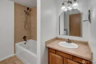 Full size tub with tile surround shower.