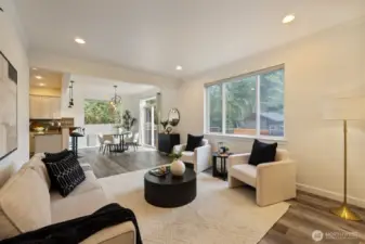 A view of the living room showing the large picture window and the dining room in the background