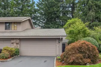 Nestled in natural surroundings, the home offers just one shared wall, driveway parking, and an attached 2-car garage with built-in shelving, a deep storage closet, and a utility sink with hose bib.