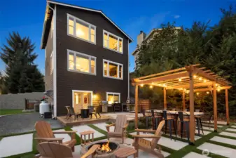 Designed for gatherings and golden-hour memories, this backyard retreat is the heart of the home. A custom pergola with ambient lighting sets the stage for al-fresco dining, while the built-in fire pit invites cozy evenings under the stars. Multiple entertaining zones — from the grilling deck to the conversation-ready patio — flow effortlessly from the home’s open interior, creating a seamless indoor-outdoor living experience.