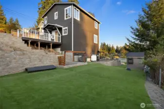 Expansive side yard designed with ease and functionality in mind. Professionally landscaped with high-quality artificial turf, this versatile outdoor space offers a lush, green look year-round — perfect for play, pets, or future garden plans. A gently sloped gravel ramp provides convenient access to the backyard and entertaining areas, blending practicality with thoughtful design.