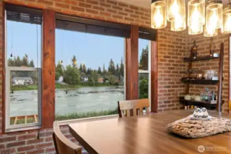 Breathtaking lake views take center stage from the dining area, creating a peaceful backdrop for everyday moments and meaningful gatherings alike. With its east-facing orientation, this space is bathed in soft morning light — the perfect spot to enjoy a quiet cup of coffee or watch the water come to life as the day begins.