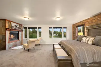Retreat to a serene primary suite designed for comfort and relaxation. Wall-to-wall carpeting adds a soft, inviting feel underfoot, while a propane-fueled fireplace creates a cozy focal point for quiet evenings. Expansive windows frame tranquil lake views, filling the space with natural light and a calming connection to the outdoors — the perfect setting for restful mornings and peaceful nights.