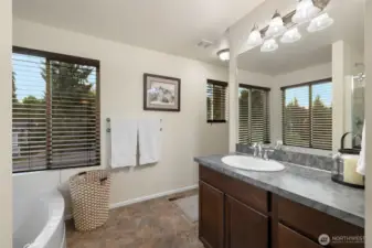The en suite bath is designed for everyday comfort and relaxation, featuring a deep soaking tub perfect for unwinding and a separate shower for daily convenience. A spacious storage closet keeps essentials neatly tucked away, while generous windows invite in natural light. Durable vinyl flooring offers easy care without compromising on style.