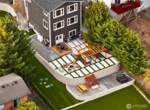 Aerial perspective shows the scale of this private retreat — beautifully terraced landscaping, dual access from the street level (at this angle the stairs on the right of home and ramp on the left), and plenty of room for outdoor living and entertaining.