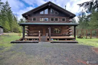 Majestic big timber log home with country front porch with swing leads you to a dream log home inside.