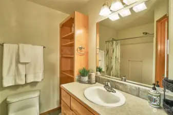 Primary bathroom, walk in shower and shelves for storage.
