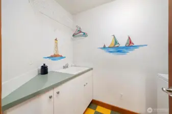 Upper level laundry room with sink and more storage.