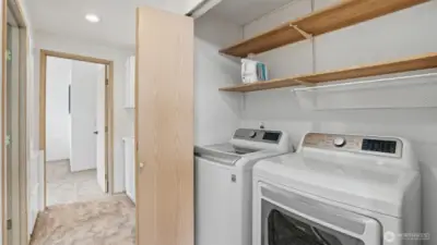 Convenient in-unit laundry with shelving and storage for everyday ease.