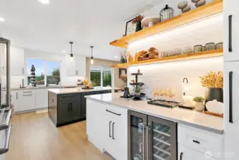 Butler's buffet between the kitchen & dining room features sleek floating shelves & a beverage fridge.