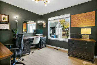 Main floor bedroom next to a full bath offers versatile space for guests, office, or additional living space.