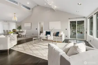 The Living room offers an open design into the formal living room (upper left) and access to the deck (upper right).  The "clear story" windows at the top of the vaulted ceiling face East guiding in the morning light.