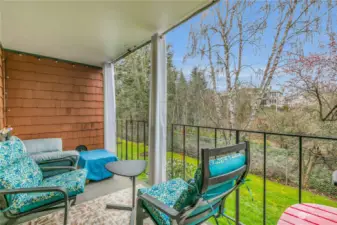 Private deck with visiting space, storage closet, a view of the greenbelt, and on a sunny day you can catch views of the Narrows Bridge.