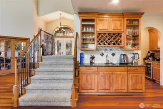Glass-fronted cabinetry enhances the designer elements of this entertainer's dream kitchen. Observe the second sink, wine rack, and added storage.