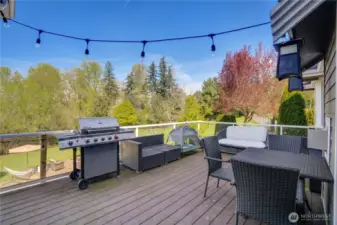 Just off of the kitchen, the spacious Trex deck with glass railing provides a perfect perch for views of the private yard.