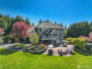 The vibrant backyard offers captivating color and views throughout the year. It features both large and small water features, terraced beds, a fire pit,