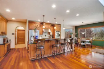 The centerpiece of the home is this inviting eat-in kitchen, complete with a charming breakfast nook. Observe the custom cabinetry that harmonizes beautifully with the rich, warm flooring.