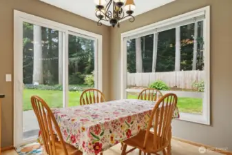 Informal kitchen eating space with windows surround and glass slider to rear yard and patio.