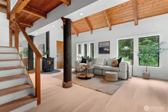 The heart of the home—soaring windows, a wood-burning fireplace, and new LVP floors.