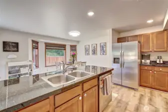 Well-laid-out kitchen with granite tile countertops, stainless steel appliances, and new LVP flooring that adds a fresh, modern touch. The open design makes it easy to cook, entertain, and stay connected with the dining and living areas.