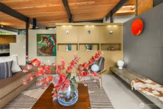 Looking back toward the entry, which is on the other side of the built-in shelving, underneath the skylight.  You can just glimpse the kitchen to the left.  Note the ingenious use of vaulted ceilings and pony walls to create architectural interest while also allowing light and air to flow freely.