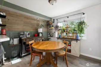 The dining room lives beautifully. Notice the pretty panelized wall with coffee bar. Too cute!